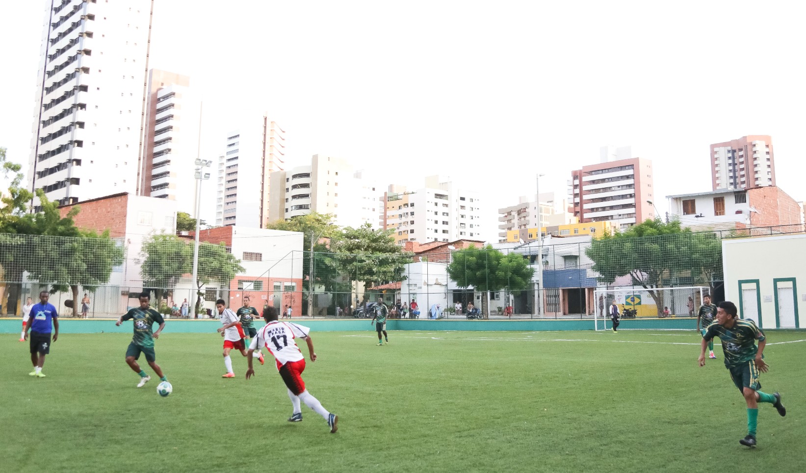 pessoas jogando futebol numa areninha